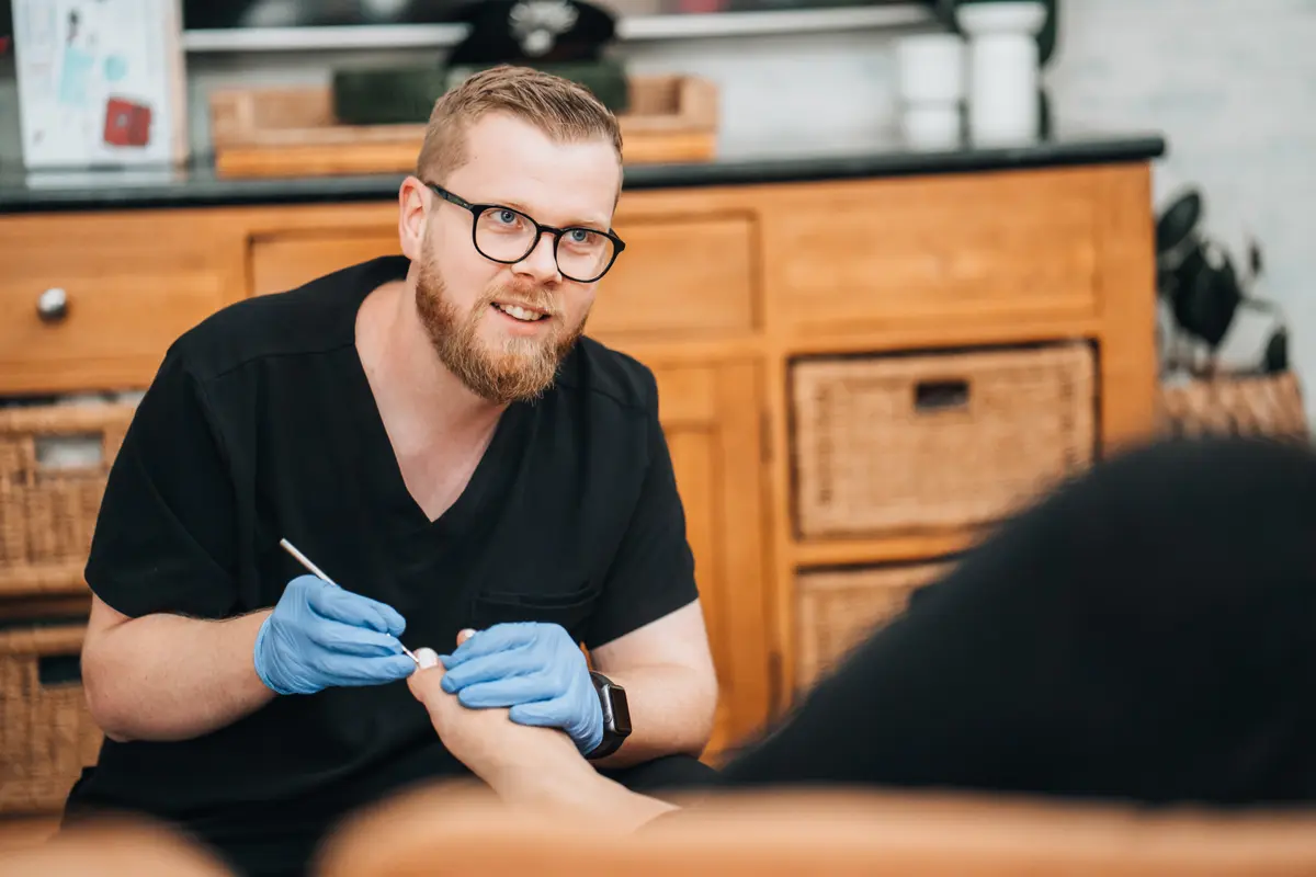 Podiatrist smiling with an older client during a home visit