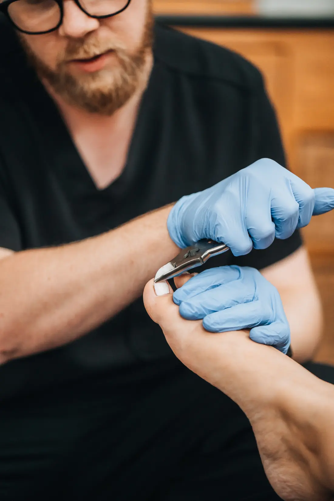 Close-up of podiatrist carefully trimming a toenail