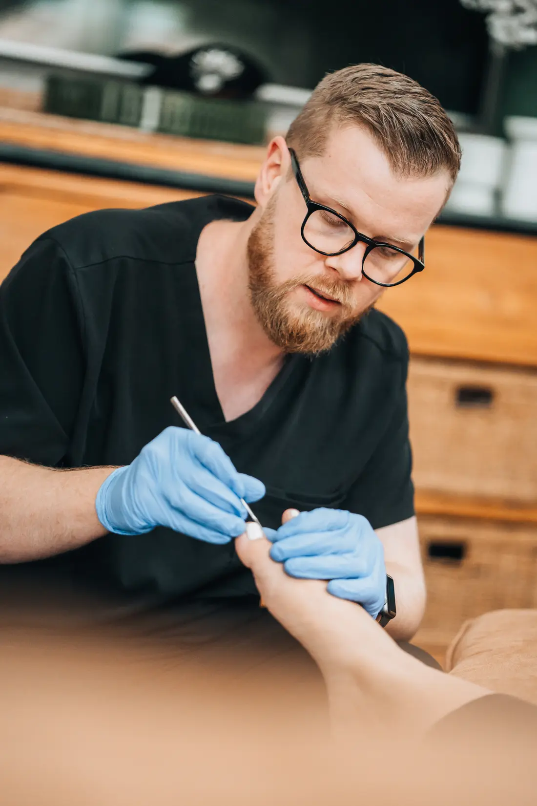 Podiatrist providing nail and foot care during an NDIS home visit